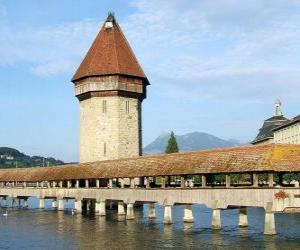 puzzel De houten en een overdekt bruggetje Kapellbrücke (de Kapel Bridge) en de toren Wasserturm in Luzern, Zwitserland