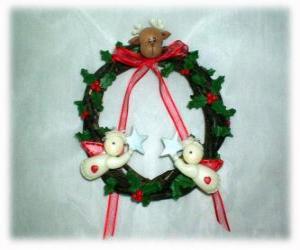 puzzel Kerstkrans versierd met bladeren hulst een hoofd van een rendier, twee engelen en een rode strik