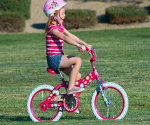 puzzel Meisje rijdt op een fiets in het park in het voorjaar