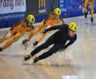 Drie schaatsers in een wedstrijd schaatsen