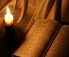 De Bijbel en een brandende kaarsen op het altaar