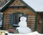 Sneeuwpop in de buurt van een huis