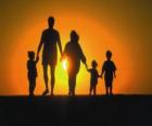 Familie, vader, moeder en kinderen lopen in de schemering tre