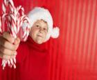 Kind met hoed van de kerstman en snoep stokken in de hand