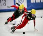 Drie schaatsers in een wedstrijd schaatsen