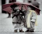 Kinderen lopen in de regen met haar paraplu