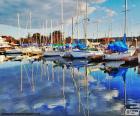 Verschillende zeilboten afgemeerd in de haven en zijn weerspiegeling in het kalme water