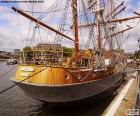 Een mooie houten zeilboot aangemeerd in de haven