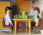 Een gelukkige familie Playmobil die bij de keukenlijst eet