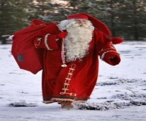 puzzel Santa Claus die de grote zak van giften van Kerstmis in het bos